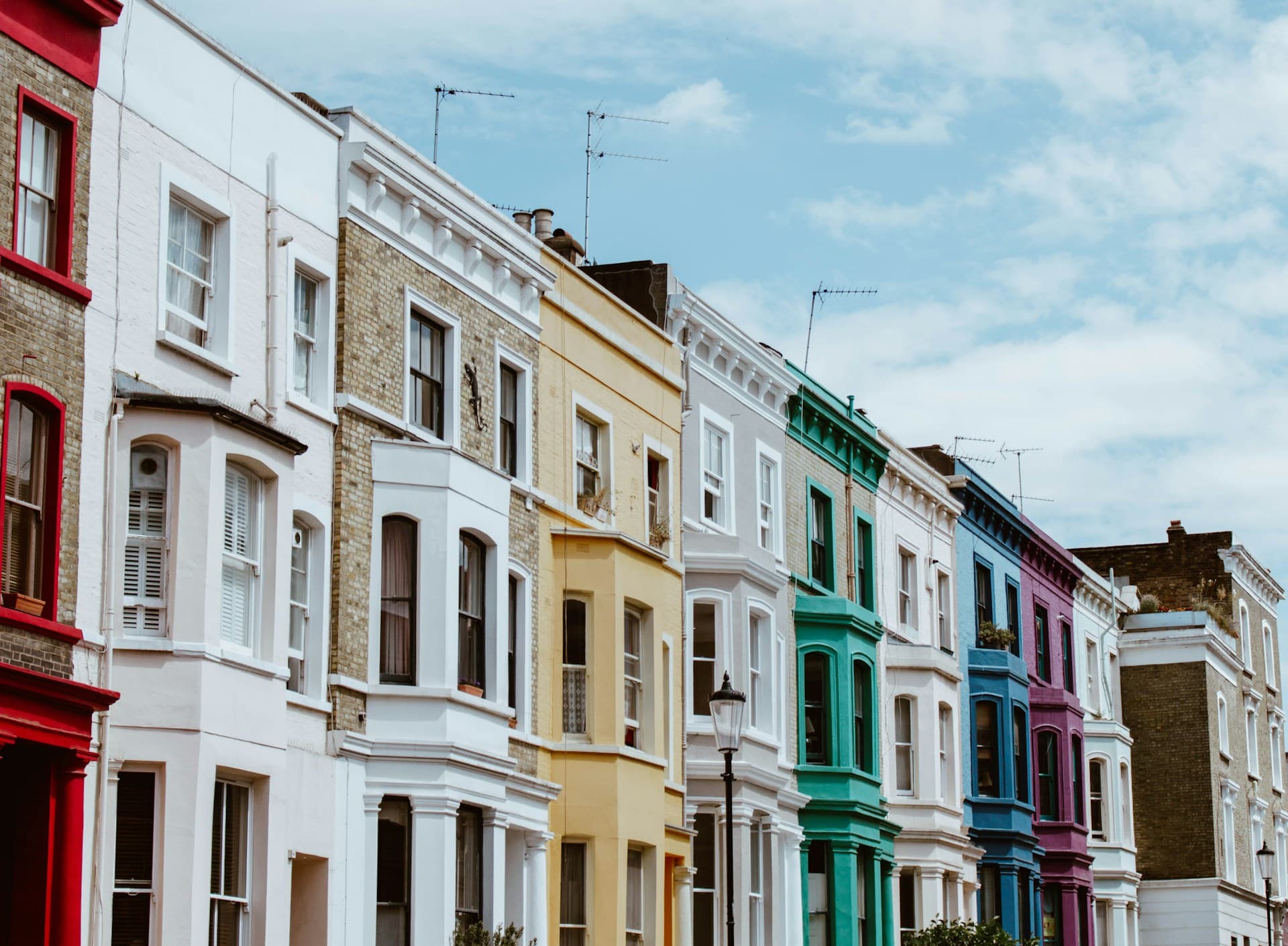 A row of colourful period houses on a residential street in London